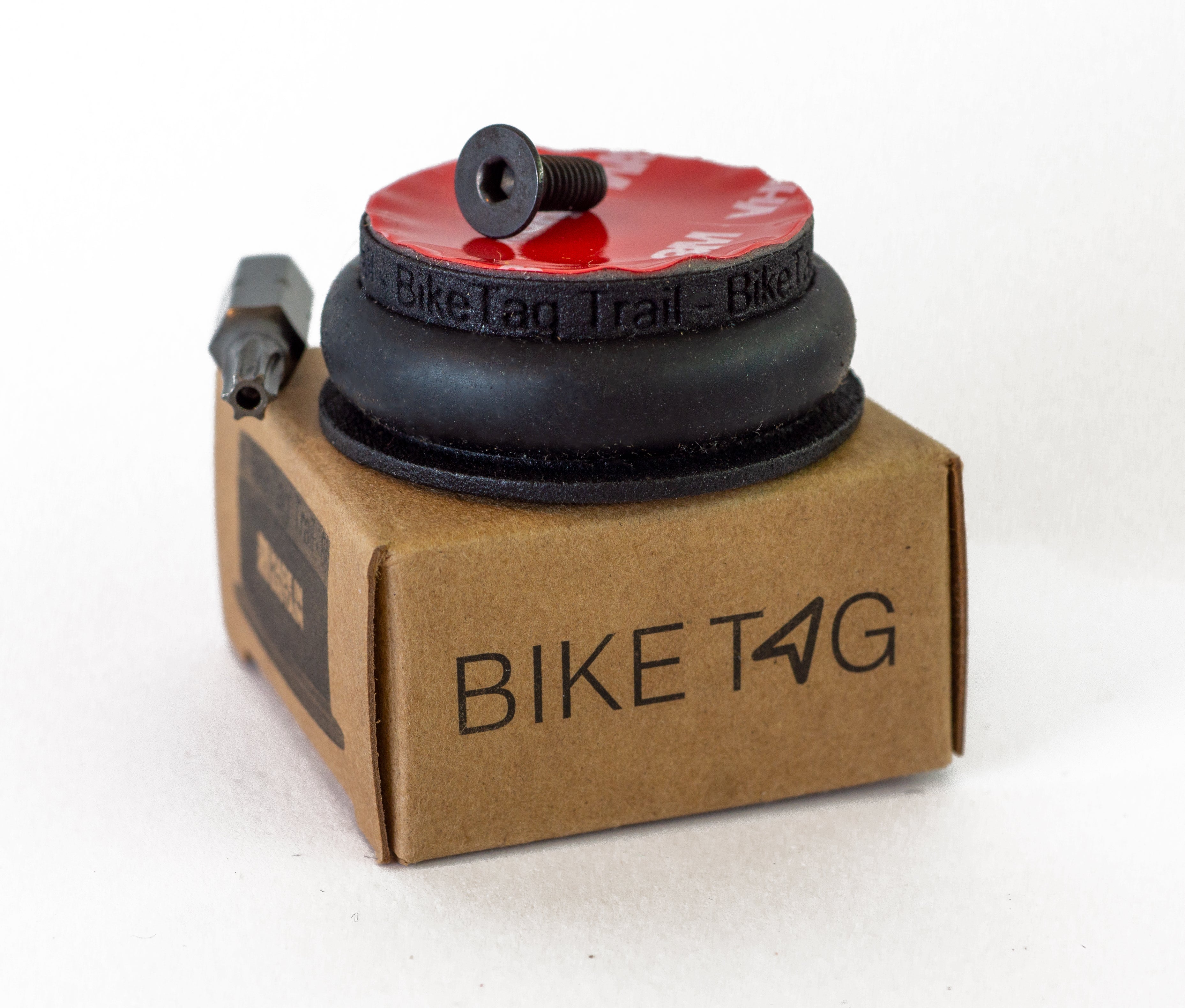 BikeTag Trail bike tracker with a security torx bit and screw resting on top of a BikeTag branded box on white background.